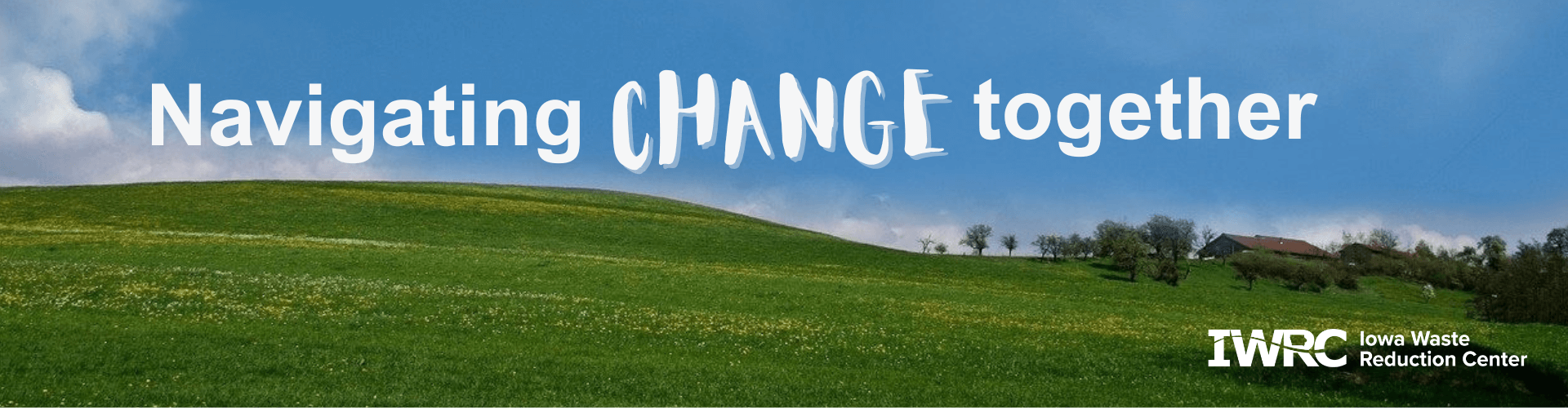 clouds forming the word change in a blue sky above green rolling hills