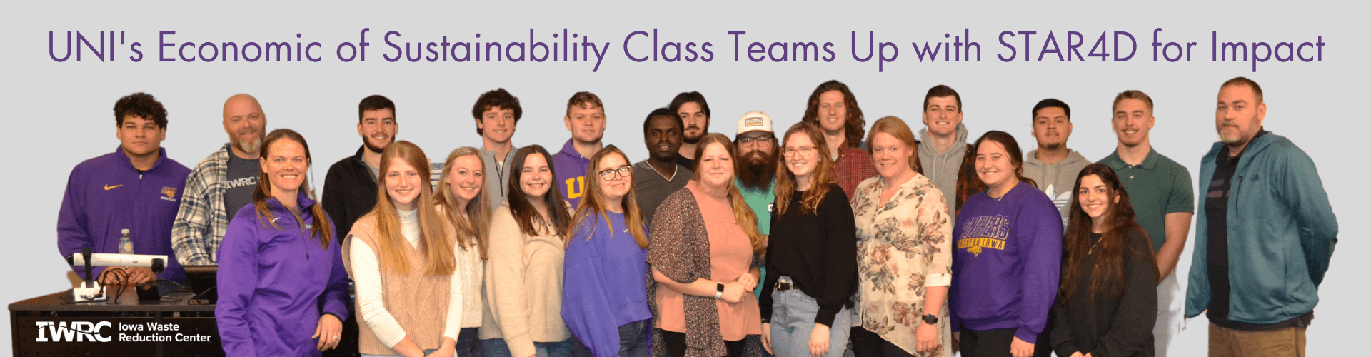 UNI students posed in front of classroom with community partner