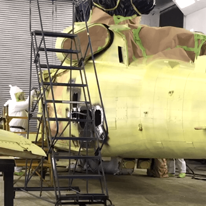Link, a military helicopter in a paint booth sits waiting to be repainted