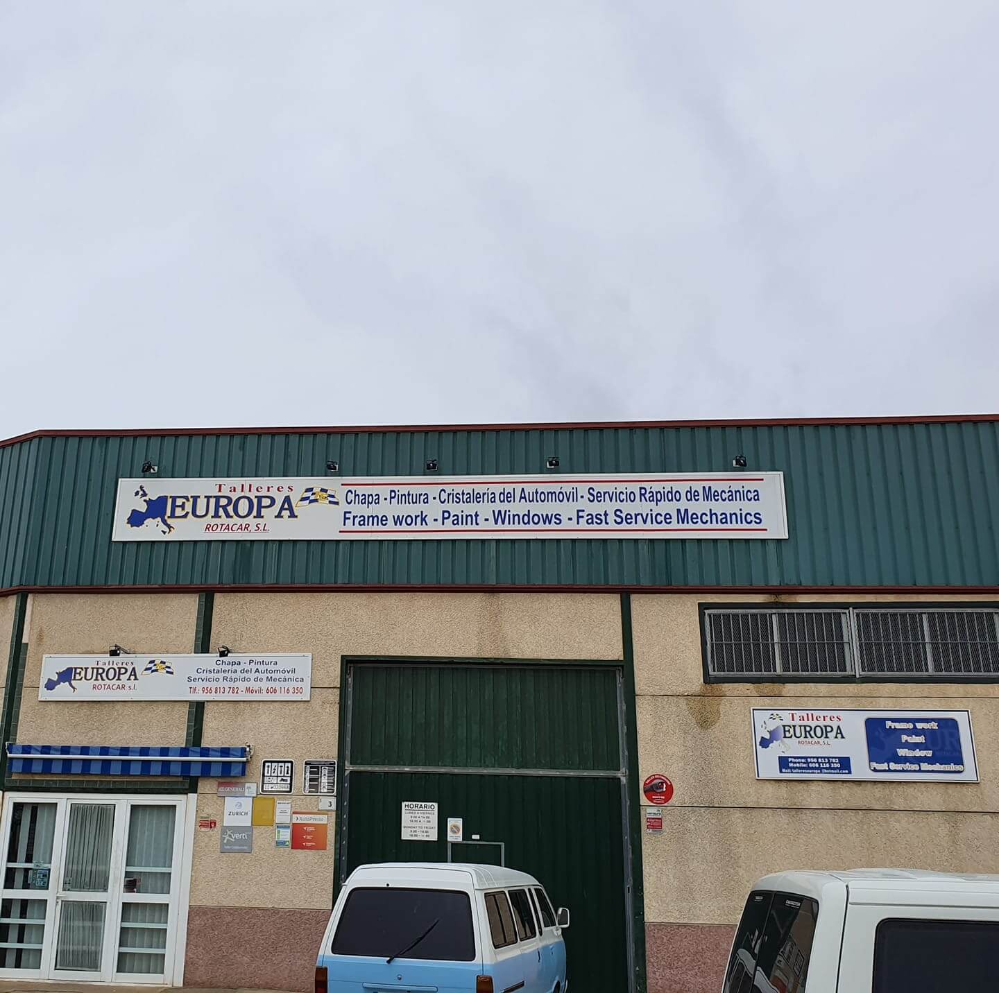 european auto body shop with green trim and brown concrete siding
