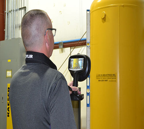 man with camera around his neck view an image of a yellow air container