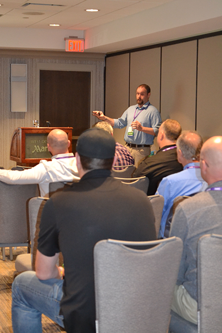 man presenting in front of conference attendees