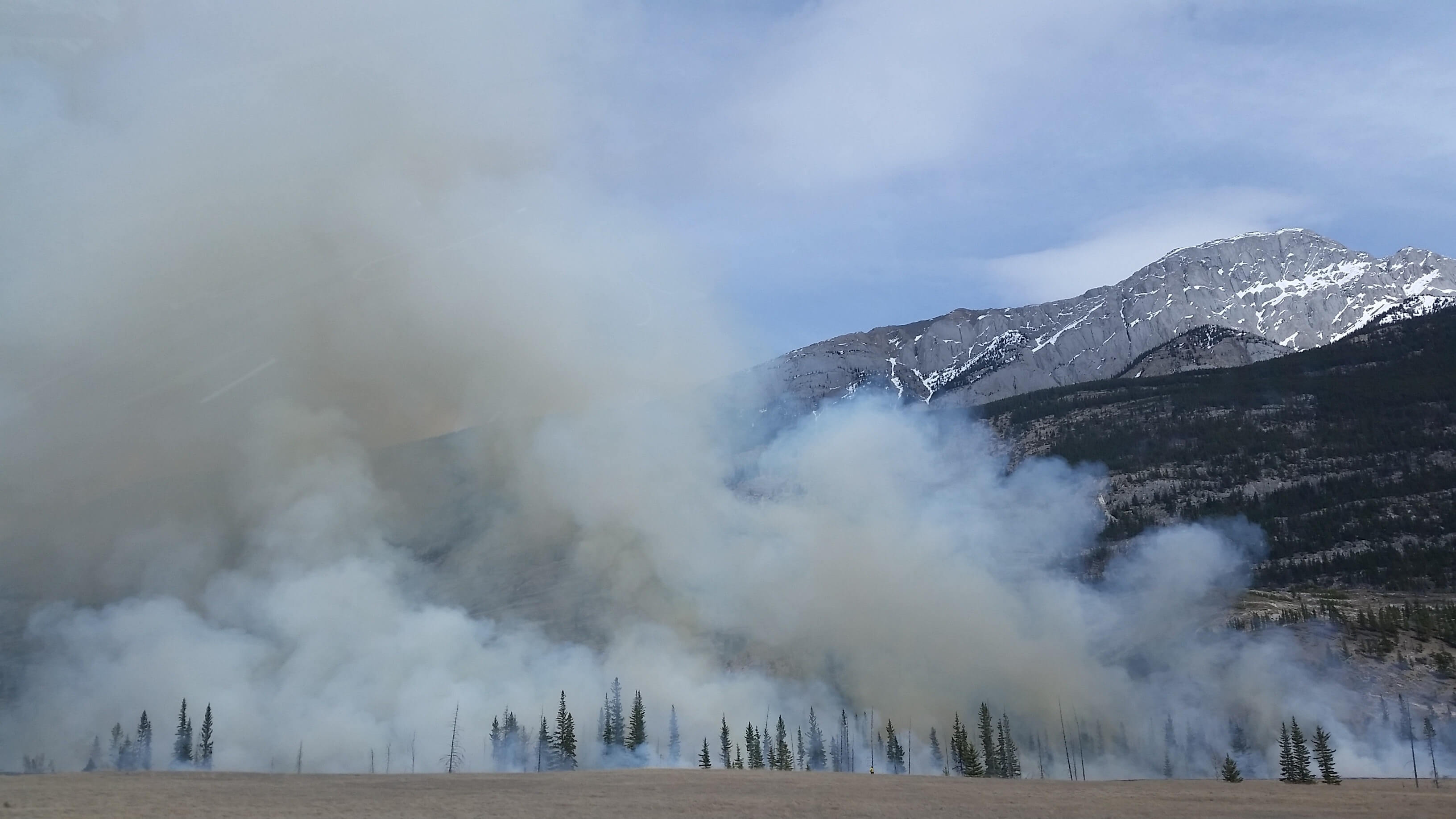 Smoke from wildfires covers the air over a mountain landscape.