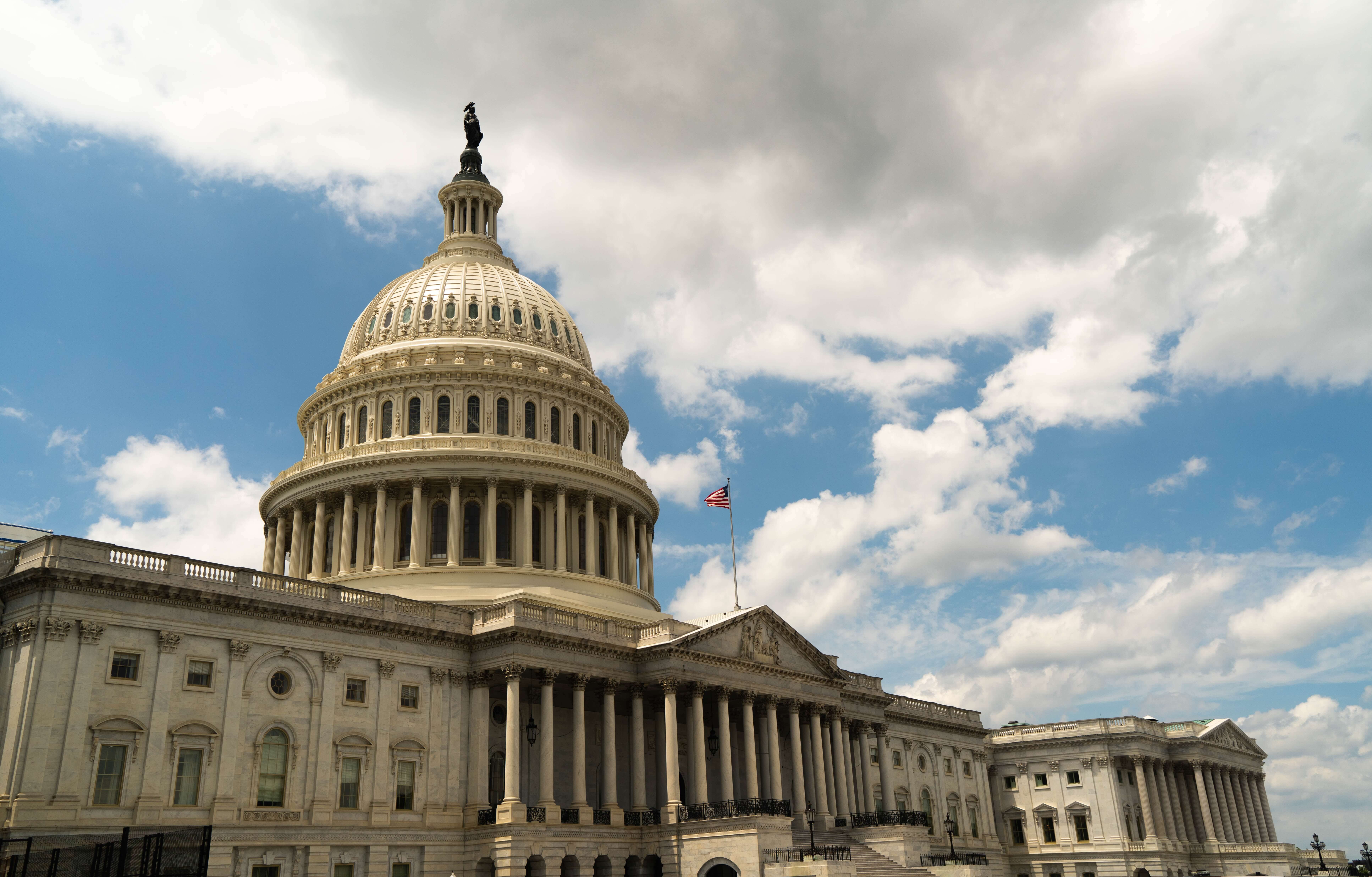 Capital building sits below blue, cloudy sky.