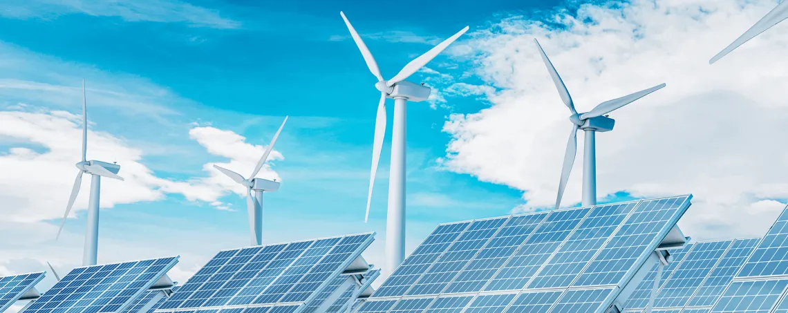 Windmills and solar panels against blue sky